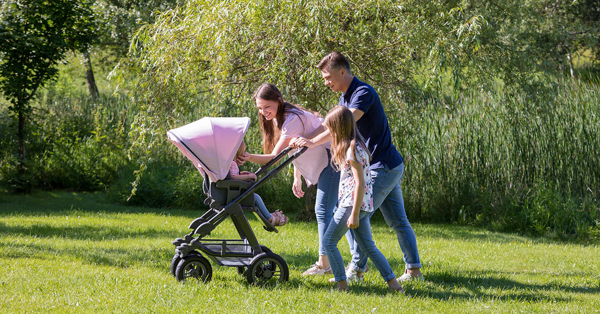 ABC Design rosafarbener Kinderwagen und Eltern