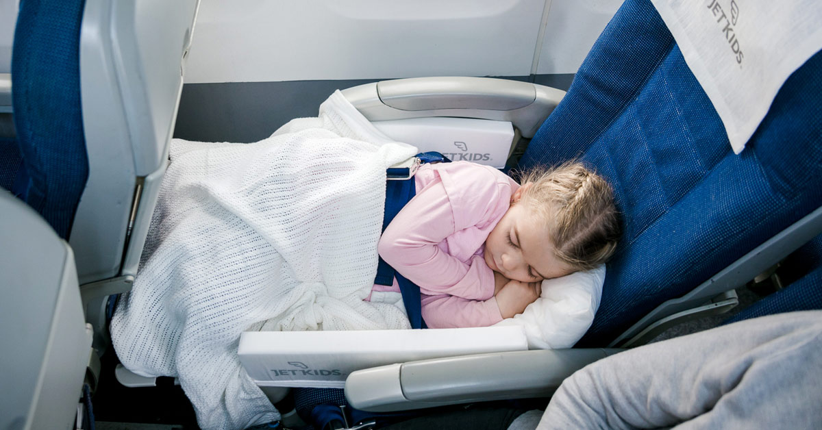 Mädchen schläft in einem Flugzeugsessel